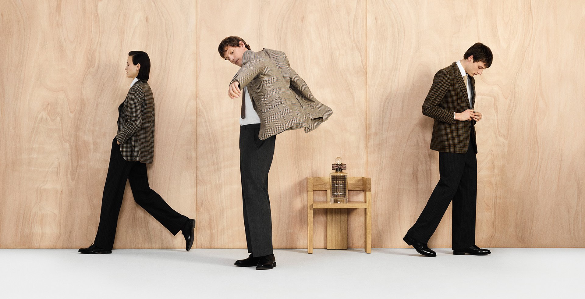 woman and two men posing in tailored suits