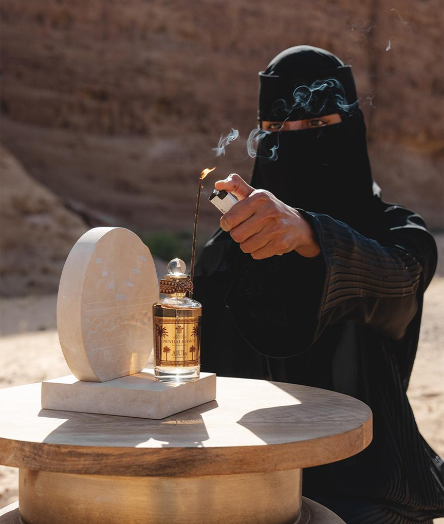 woman lighting incense next to Alula perfume